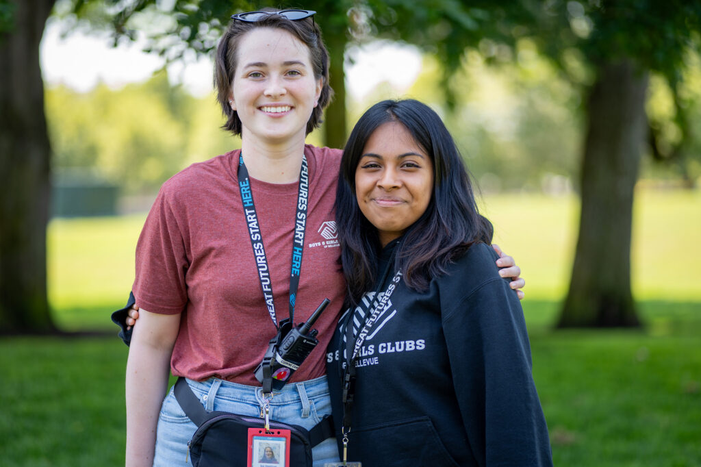 Two BGCB Staff smiling and hugging looking at the camera.