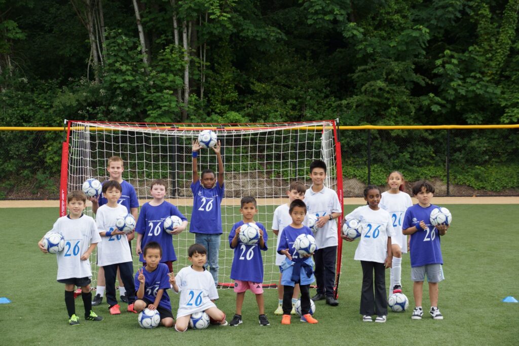 Allstar soccer game with kids standing in front of goal.