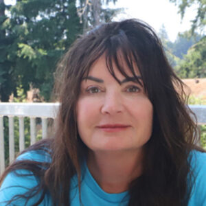 Woman sitting outside at a table.
