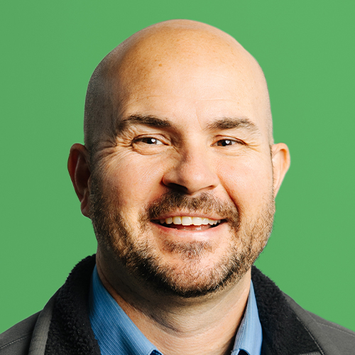 Man in front of green background.